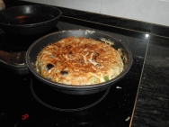 Con la tortilla en la sartén.