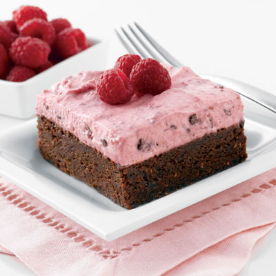 Mousse de frambuesas encima de brownie de nueces y crema inglesa