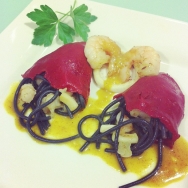 piquillos rellenos de fideos negros,langostinos y calamares con salsa suave de curry y grana padamo