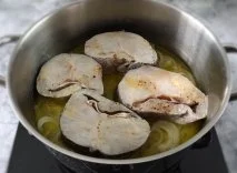 Merluza con una cama de cebollas