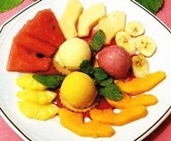 Postre de sorbetes y frutas tropicales con coulis